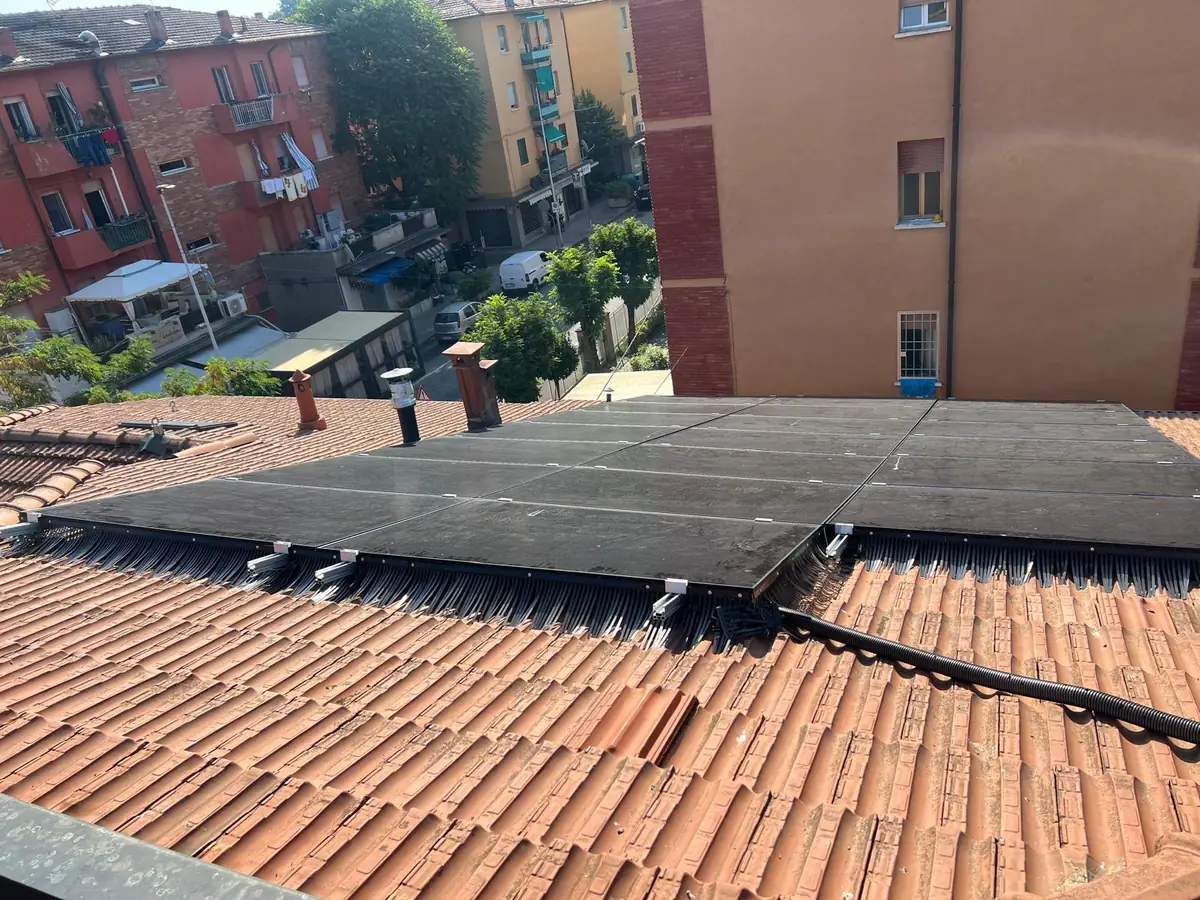 Protezione anti-piccioni sotto i pannelli fotovoltaici su tetto di un edificio in città