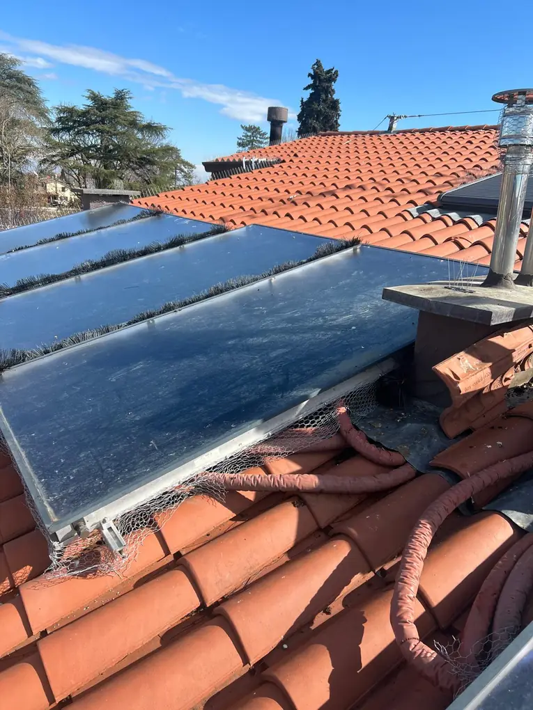Rete anti-piccioni sotto un collettore solare termico, attorno alle tubazioni