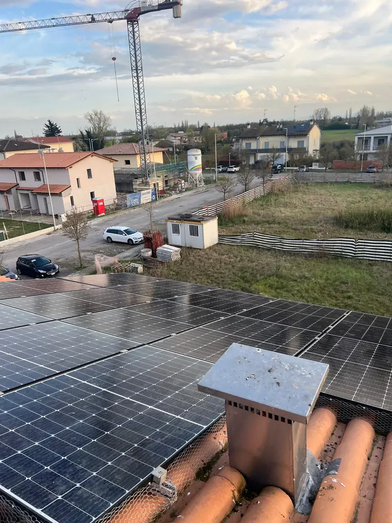 Rete anti-piccioni attorno ai pannelli fotovoltaici vicino al comignolo